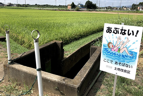 ポールと注意看板で水路の危険を示す