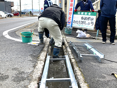 側溝に新しい材料を入れる